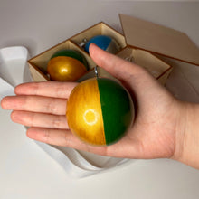 Load image into Gallery viewer, Scale of wooden xmas tree ornament. Round sphere shape golden/green bauble. Made by an artist Anastasia Kurganova
